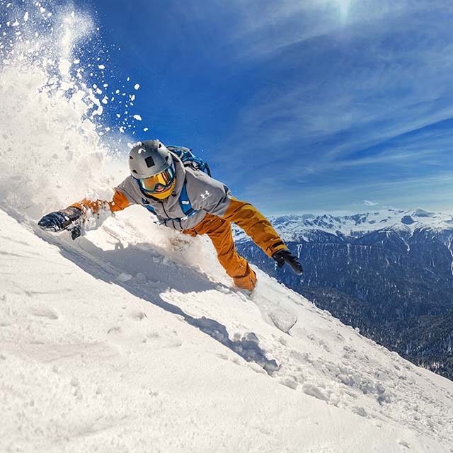 A person on a snowboard going down a mountain